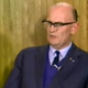 Clarke, firmly grounded in the 1970s thanks to a wood-paneled interview backdrop.